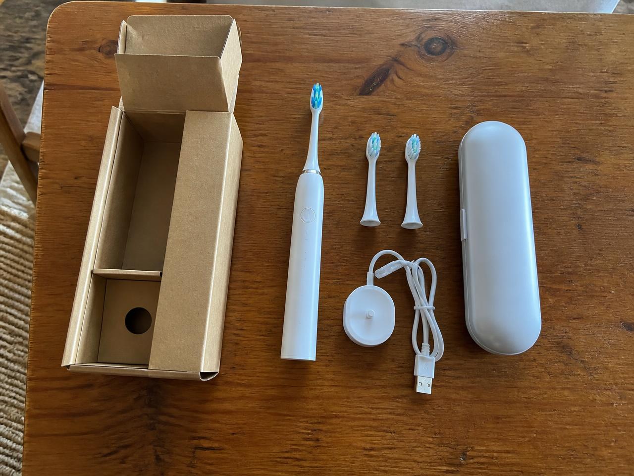 Contenuto della confezione del SonicX PRO: manico, testine di ricambio, base di ricarica USB e custodia da viaggio